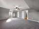 A large bedroom with gray carpet, a ceiling fan, and multiple doors, providing access to closets and other areas at 410 Invector Ct, Locust Grove, GA 30248