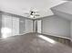 Large bedroom features soft carpeting, a ceiling fan, and closet storage, offering comfort and convenience at 410 Invector Ct, Locust Grove, GA 30248