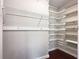 Walk-in closet featuring custom shelving and ample storage, with hardwood flooring at 410 Invector Ct, Locust Grove, GA 30248