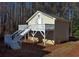 Exterior view showcasing a detached garage, stairs, and natural surroundings at 410 Invector Ct, Locust Grove, GA 30248