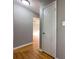 A hallway featuring hardwood floors and neutral walls leads to rooms throughout the house, complemented by a white door at 410 Invector Ct, Locust Grove, GA 30248
