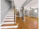 Open-concept living area with hardwood floors, a staircase, and neutral wall colors at 410 Invector Ct, Locust Grove, GA 30248