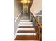 A beautiful staircase with wooden steps, white risers, and decorative metal railings leads to the upper levels of the home at 410 Invector Ct, Locust Grove, GA 30248
