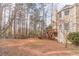 Expansive backyard featuring mature trees, a deck, and the home's exterior, ideal for outdoor activities at 1351 Mckendree Park Ct, Lawrenceville, GA 30043