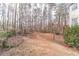 View of the backyard with mature trees and partial views of the exterior; landscaping and natural beauty abound at 1351 Mckendree Park Ct, Lawrenceville, GA 30043