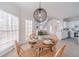Bright dining area features a modern chandelier, seating for four, and access to the deck and kitchen at 1351 Mckendree Park Ct, Lawrenceville, GA 30043