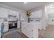 Well-lit kitchen with white cabinets, stainless steel appliances, island, and easy access to pantry at 1351 Mckendree Park Ct, Lawrenceville, GA 30043