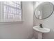 Powder room featuring a stylish vessel sink, modern faucet, and a round mirror at 1351 Mckendree Park Ct, Lawrenceville, GA 30043