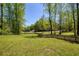 Large grassy backyard enclosed by a wooden fence and bordered by mature trees, providing privacy and a natural setting at 5570 Rolling Oaks Dr, Cumming, GA 30040