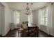 Cozy dining room featuring a chandelier, hardwood floors, and large windows for natural light at 5570 Rolling Oaks Dr, Cumming, GA 30040