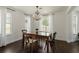 Bright dining room featuring a chandelier, wood table and floors, and natural light from windows at 5570 Rolling Oaks Dr, Cumming, GA 30040