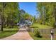 Charming single-Gathering home featuring a long driveway and a beautifully landscaped front yard with mature trees at 5570 Rolling Oaks Dr, Cumming, GA 30040