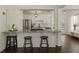 Modern kitchen features stainless steel appliances, granite countertops, white cabinetry and bar stool seating at 5570 Rolling Oaks Dr, Cumming, GA 30040