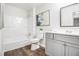 Bright bathroom featuring a shower-tub combo and single sink vanity with wood-style floors at 6615 Buckhurst Trl, Atlanta, GA 30349