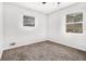 Cozy bedroom with two windows, carpet floors, and neutral-colored walls at 6615 Buckhurst Trl, Atlanta, GA 30349