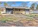 Backyard view of home featuring a new wooden porch with railing, and large trees overhead at 8329 Marlborough Dr, Jonesboro, GA 30238
