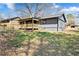 Backyard view of home featuring a new wooden porch with railing, and large trees overhead at 8329 Marlborough Dr, Jonesboro, GA 30238