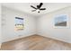 An open and airy bedroom featuring wood flooring, ceiling fan and bright natural light from two windows at 8329 Marlborough Dr, Jonesboro, GA 30238