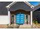 Close-up of modern blue front door flanked by windows and manicured greenery adding charm to the entrance at 1041 Walker Se Ave, Atlanta, GA 30316