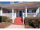 Inviting front porch with red stairs, white columns, and blue shutters for curb appeal at 105 Condor Ct, Woodstock, GA 30188
