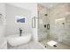 New bathroom featuring a modern tub, a frameless glass shower with marble tile, and bright, natural light at 2860 3Rd Sw Ave, Atlanta, GA 30315