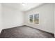 A clean and modern bedroom with neutral walls, plush carpeting, and a sunlit window with outdoor views at 2860 3Rd Sw Ave, Atlanta, GA 30315