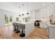 Spacious kitchen with white cabinets, quartz countertops, stainless steel appliances, an island with seating, and hardwood floors at 2860 3Rd Sw Ave, Atlanta, GA 30315