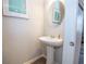 Small bathroom featuring pedestal sink, modern faucet, and accent wall art at 6338 Kinsland Ct, Lithonia, GA 30058