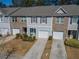 Townhome with blue siding, brick accents, and a single-car attached garage at 6338 Kinsland Ct, Lithonia, GA 30058