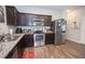 Stylish kitchen featuring stainless steel appliances, granite countertops, and wood-look flooring at 6338 Kinsland Ct, Lithonia, GA 30058