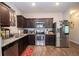 Well-equipped kitchen with stainless steel appliances, granite countertops, and dark wood cabinetry at 6338 Kinsland Ct, Lithonia, GA 30058