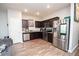 Well-appointed kitchen featuring stainless steel appliances, dark cabinets, and stylish flooring at 6338 Kinsland Ct, Lithonia, GA 30058