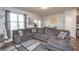 Spacious living room with large gray sectional couch, wood floors, and multiple windows for natural light at 6338 Kinsland Ct, Lithonia, GA 30058