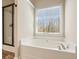Bright bathroom featuring a soaking tub with a shower, and laminate flooring at 4460 Wimberly Way, Cumming, GA 30028