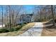 Beautiful two-story home with a long driveway surrounded by lush trees and landscaping at 4460 Wimberly Way, Cumming, GA 30028