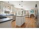 Open kitchen with stainless steel appliances, island, and hardwood floors connecting seamlessly with the living area at 4460 Wimberly Way, Cumming, GA 30028