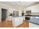Spacious kitchen featuring white cabinets, stainless steel appliances, hardwood floors, and a functional center island at 4460 Wimberly Way, Cumming, GA 30028