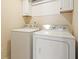 Clean laundry room with new white washer and dryer, and overhead cabinets at 4460 Wimberly Way, Cumming, GA 30028