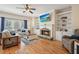 Cozy living room with stone fireplace, built-in shelving, hardwood floors, and comfortable seating at 4460 Wimberly Way, Cumming, GA 30028
