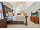 Spacious main bedroom with tray ceilings, dark wood furniture, and a flat screen TV at 4460 Wimberly Way, Cumming, GA 30028