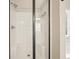 Close-up of a shower stall with a glass door and shower head and neutral tiling at 4460 Wimberly Way, Cumming, GA 30028