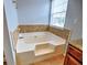 Corner bathtub featuring decorative tile in a bathroom with a window at 4871 Ship Jack Ln, Decatur, GA 30035