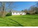 Expansive backyard with lush green lawn, mature trees, and a charming house, perfect for outdoor activities at 6365 Mountain View Trl, Cumming, GA 30041