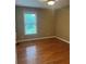 This bedroom offers wood floors, a window with natural light, and a neutral color scheme at 6365 Mountain View Trl, Cumming, GA 30041