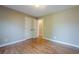 Bedroom featuring hardwood floors, neutral walls, and double door closet providing ample storage space at 6365 Mountain View Trl, Cumming, GA 30041