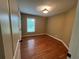 A cozy bedroom shows beautiful wood floors and a window view to the outdoors at 6365 Mountain View Trl, Cumming, GA 30041
