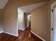 Hallway featuring hardwood floors and neutral paint, seamlessly connecting various parts of the home in style at 6365 Mountain View Trl, Cumming, GA 30041