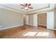 A large bedroom with a ceiling fan, spacious closet, and hardwood flooring at 6365 Mountain View Trl, Cumming, GA 30041