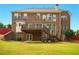 Two-story brick home with a wooden deck, stairs, and a grassy backyard at 8056 Revere Dr, Mcdonough, GA 30252