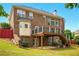 Two-story brick home with a wooden deck, stairs, and a grassy backyard at 8056 Revere Dr, Mcdonough, GA 30252